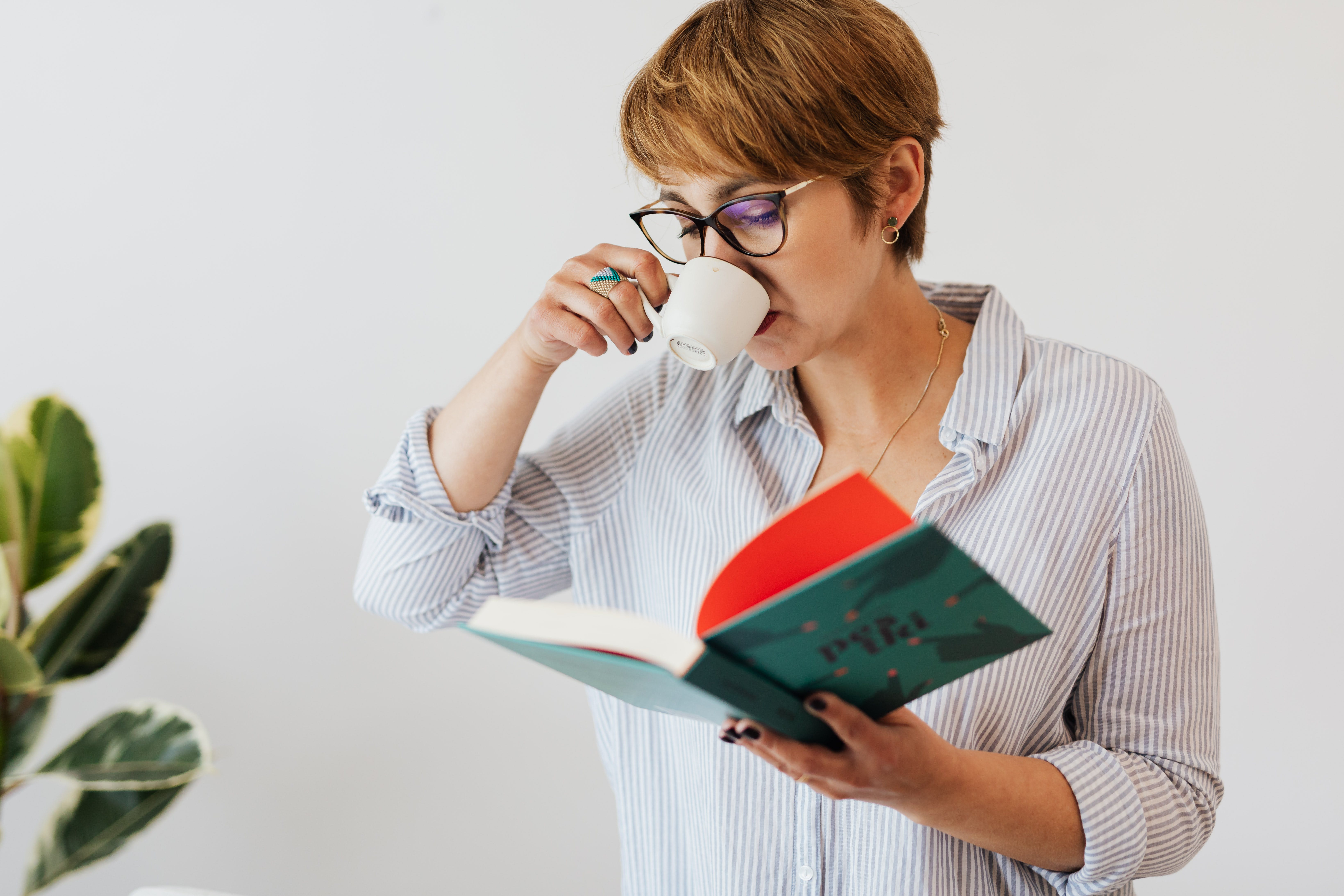 A Woman Drinking Coffee and Reading a Book